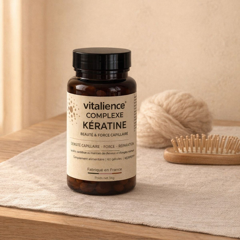 Flacon Complexe Kératine sur une commode en chêne, pelote de laine brute et brosse en bois, lumière de fenêtre.